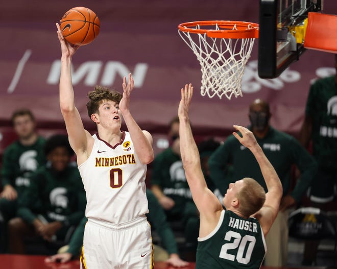 Liam Robbins (0) from Minnesota Jover hits Michigan state striker Joy Hauser (20) on December 28, 2020, during the first half at the Williams Arena.