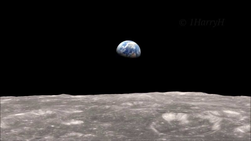Half of the Earth is floating in the black sky over the gray moon's cratered surface.