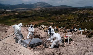 Cemetery workers wearing protective gear bury a coronavirus victim in Tijuana.