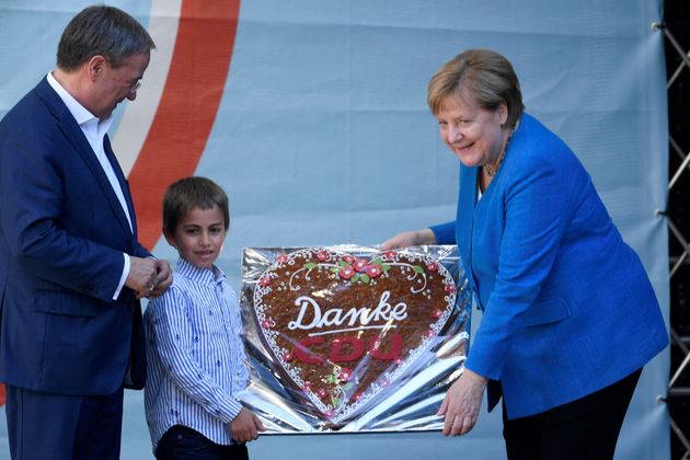 German Chancellor Angela Merkel (right) receives a gingerbread heart written on it 