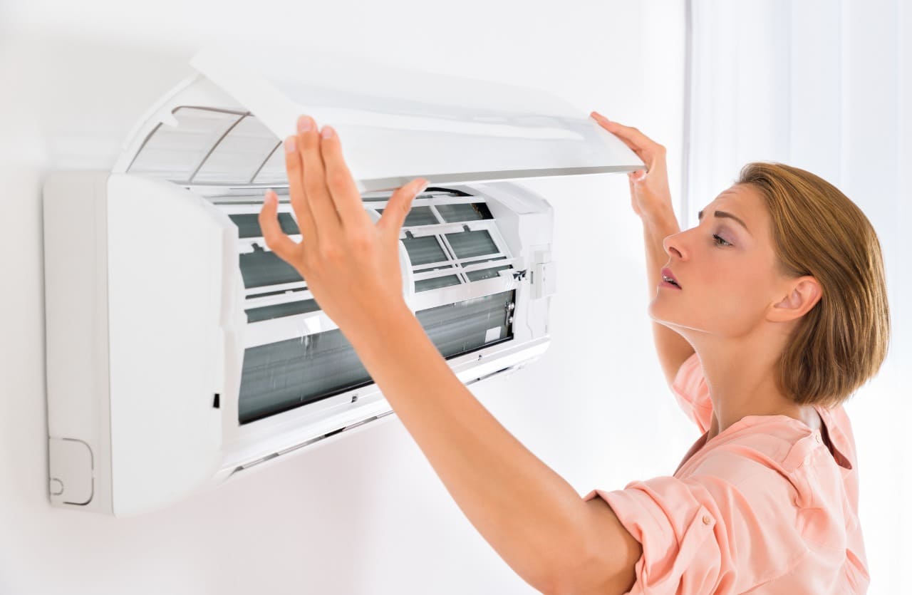 Woman looking at the exposed air conditioner