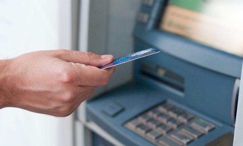 hand-inserting-atm-card-into-bank-machine-to-withdraw-money-businessman-men-hand-puts-credit-card-into-atm